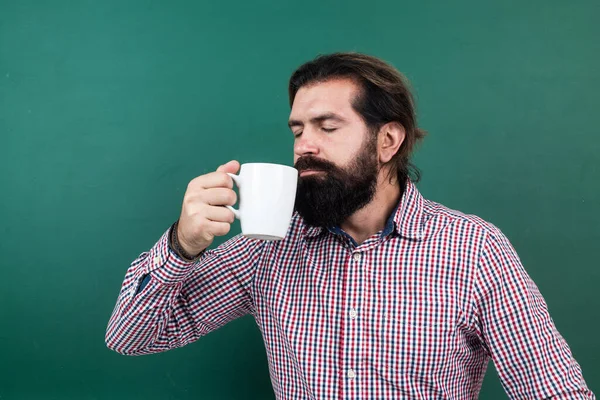 Brutal unshaven cara professor universitário em quadro-negro, café da manhã — Fotografia de Stock