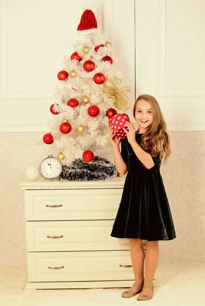 Το καλύτερο για τα παιδιά μας. Το παιδί γιορτάζει τα Χριστούγεννα στο σπίτι. Αγαπημένη μέρα του χρόνου. Ένα κοριτσάκι κοντά σε κουτί δώρου με χριστουγεννιάτικα δέντρα. Ώρα να ανοίξουμε χριστουγεννιάτικα δώρα. Καλά Χριστούγεννα. Τα όνειρα γίνονται πραγματικότητα — Φωτογραφία Αρχείου