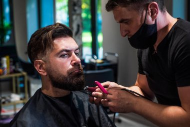 Berber dükkanında yakışıklı bir adamın saçını kesen çekici berber, kuaför aletleri.