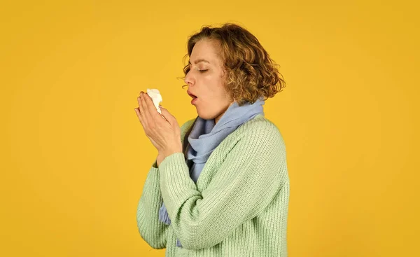 Hosta i en servett. rinnande näsa. En kvinna med allergi som blåser sig i näsan. Begreppet utbrott av coronavirus. En sjuk kvinna som nyser hemma. Håll näsduken mot Runny Nose. begrepp för behandling av allergier eller förkylningar — Stockfoto