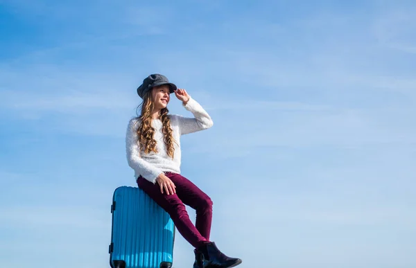 Kind met reiskoffer met trendy muts op. concept van reizen. Kindergeluk. Klaar voor de vakantie. gevoel van vrijheid. gelukkig tiener meisje op lucht achtergrond. lente kid mode stijl — Stockfoto