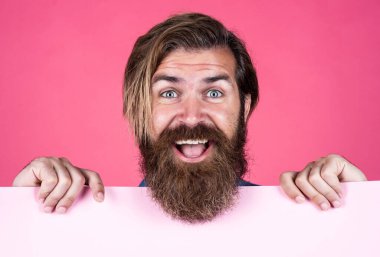 Saf mutluluk. Erkek berber yüz bakımı. Kendine güvenen ve yakışıklı. Duyuru ve reklam. Mutlu gülümseyen olgun adam. Sakallı adam pankartı tutuyor. Bıyıklı, vahşi, beyaz bir hippi.
