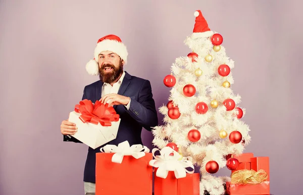 Vánoční dárky a dekorace. Tajný Santa koncept. Kup dárek. Zimní prázdniny. Vánoční pozdravy. Nejlepší dárkový obchod. Vánoční večírek v kanceláři. Muž vousatý hipster formální oblek v blízkosti vánoční strom — Stock fotografie