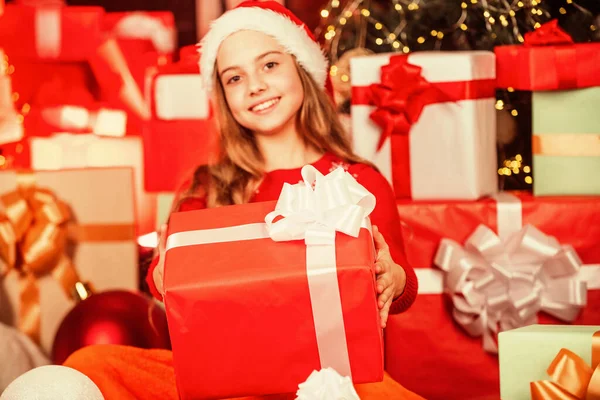 Decorado con regalos. paquetes de compras venta de Navidad. alegre santa ayudante tipo regalos. asistente de tienda sonriente. niño en sombrero de santa con muchas cajas de regalo. compras exitosas en el mercado de Navidad —  Fotos de Stock