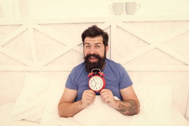 Alarmlı saatle yatakta yatan adamın mutlu uyanması. Adam uyanıyor. Sabahleyin çalar saat. Erkek Sağlığı konsepti. Bekarlığa veda günü şimdi başlıyor, sabah ereksiyonu. Yeterince sağlıklı uyku