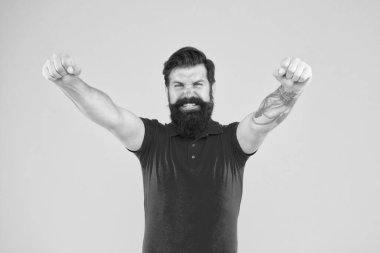 Neşeli adam. İç enerji. Başarı için motive. Mutlu adam sarı arka planda başarı jesti gösteriyor. Zafer ve başarı. Sıradan giyinmiş sakallı adam kutlama yapıyor. Mutluluk ve neşe. Kazanan ve kazanan