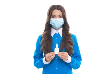 Maskeli kız burun damlası tutuyor. Çocuk burun spreyi kullanıyor. Burun akıntısı koronavirüs semptomu. Grip salgını terapisi. Semptomatik tedavi. Virüs salgını riski var. çocuk etkili ilaçlar kullanıyor