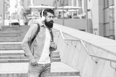 İşe günlük rota. Modern hayat. Manzara değişikliği konsepti. Sırt çantası olan yakışıklı bir hippi. Boş sokaklarda yürüyorum. Şehir merkezinde yürüyen kulaklıklı bir adam. Müzik dinlerken