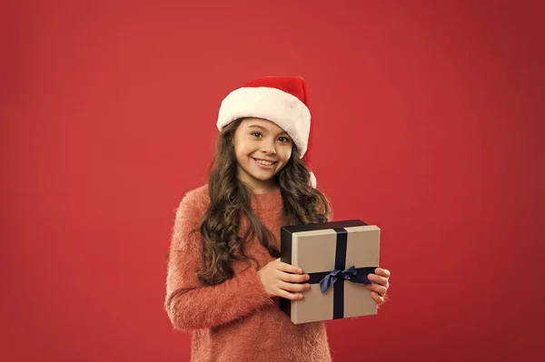 Ez az enyém. vidám gyermek vörös fal. gyerek vásárlás eladások. Karácsonyi boksz nap. a legjobb karácsonyi ajánlat. Egy kislány fogja az ajándékdobozt. Boldog újévi ajándékot. Karácsonyi ünnepi buli. Mikulás sapkás kislány — Stock Fotó
