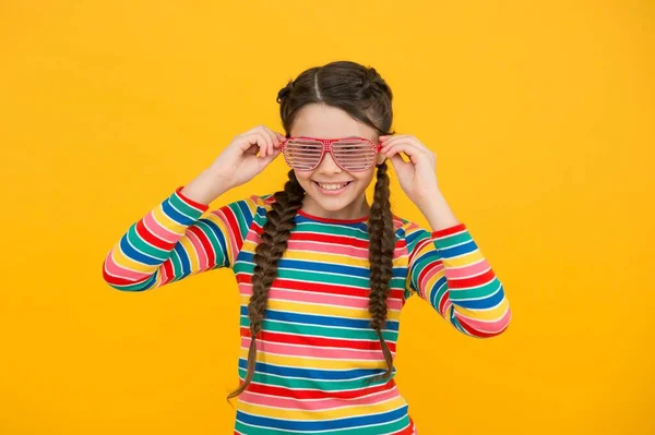 Menina adolescente feliz com cabelo trançado usar estilo casual cor do arco-íris e óculos de festa glamour no fundo amarelo, moda — Fotografia de Stock