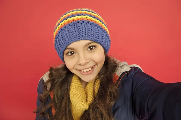 Câmara selfie. Cara engraçada sorridente. Menina usar roupas de inverno fundo vermelho. Conceito de infância. Menina emocional chapéu de malha de cabelo longo. Adolescente estilo casual menina. Emoções e humor. Blog pessoal — Fotografia de Stock