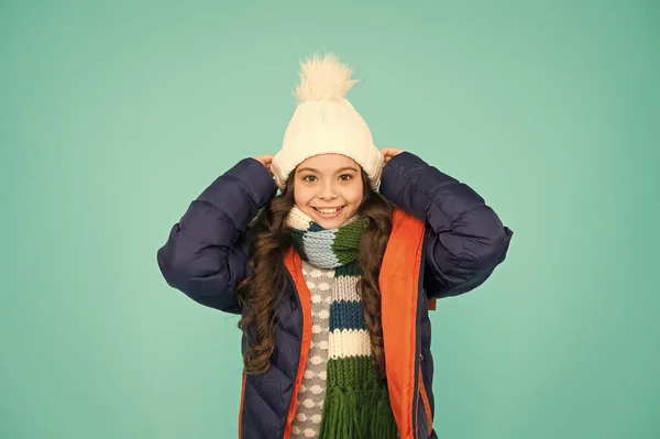 Koud seizoen winkelen. Kind in gewatteerde warme jas. Seizoensgebonden mode. Fijne wintervakantie. Mode meisje winterkleding. Mode trend. Een klein kind draagt een hoed en een blauwe achtergrond. Wintersport — Stockfoto