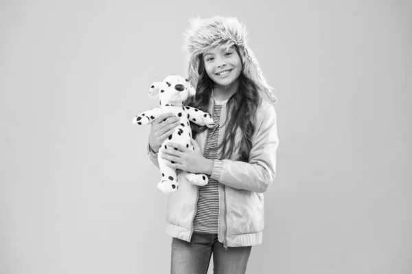 장난감 가게 방문. 달마티아 소녀의 강아지입니다. 가을 스타일. 어린 시절의 행복. 핑크 색 배경의 행복 한아이. 애들 패션이요. 섹시 한 아가씨의 모피 겨울 귀걸이 모자. 따뜻 한 옷 액세서리를 한 추운 계절 — 스톡 사진