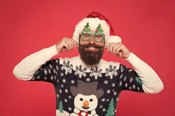 Modedesign, um festlich zu bleiben. Mode Weihnachtsmann roten Hintergrund. Glücklicher Mann wirbelt modischen Schnurrbart. Stilvolle Trends für die Feiertage. Frohe Weihnachten. Neues Jahr, neue Mode — Stockfoto