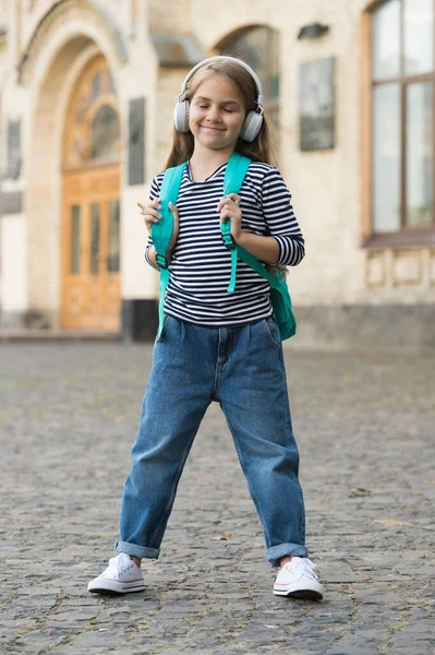 Criança feliz gosta de ouvir música tocando em fones de ouvido modernos com olhos fechados em estilo casual moda urbana ao ar livre, infância — Fotografia de Stock