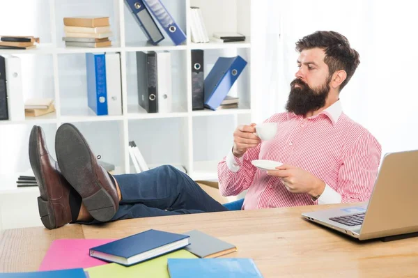 留胡子的男人喜欢在办公桌前喝茶或咖啡，享受快乐 — 图库照片