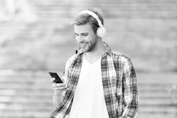 Disconnect from the outer world. Happy guy make video call using mobile phone. Handsome man listen to music on phone. Smart phone. Music player. MP3. Music app on phone. New technology. Modern life