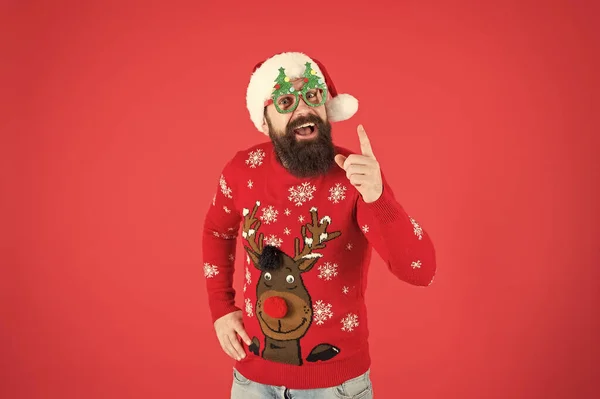 Winter presentation. Happy new year celebration. Join holiday celebration. Party outfit. Sweater with deer. Hipster bearded man wear winter clothes red background. Christmas celebration ideas — Stock Photo, Image