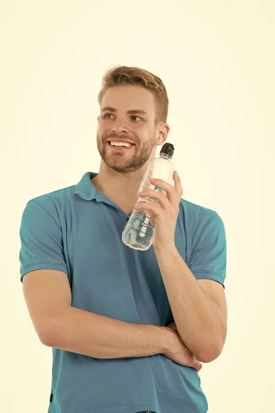 Gesundheit und Hydratation. Glückliche Kerl halten Wasserflasche isoliert auf weiß. Durstiger Mann trägt Poloshirt. Durst und Wasserverlust. Wasserhaushalt im menschlichen Körper. Gesunde Aufnahme und Produktion. Mehr Wasser trinken — Stockfoto