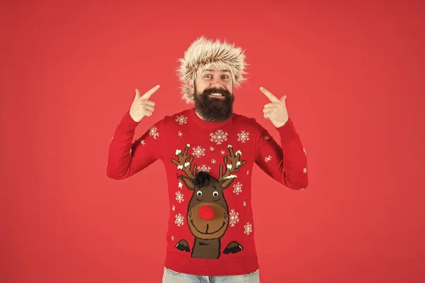 Bearded man smiling on red background. funny man with beard in knitted sweater. cheerful hipster ready for xmas party. winter holiday celebration. cold weather fashion for men. happy new year — Stock Photo, Image