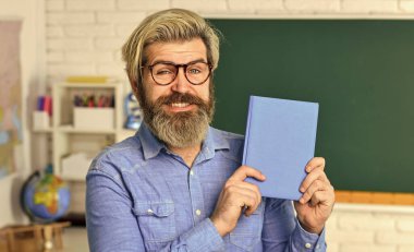 Öğrenmek için ilham verici. Modern okul. Özel ders. Okul projesi. Edebiyat ve şiir. Okula dönelim. Sakallı adam kitap okuyor. Bilişsel gelişim. Öğretmen üniversitede çalışıyor. Eğitim kavramı