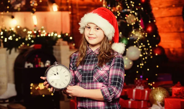 Conoce las vacaciones de Navidad. Ambiente festivo el día de Navidad. Cuenta atrás de año nuevo. Contando el tiempo. Faltan pocos minutos para el año nuevo. Llega el momento mágico. Navidad casi aquí. Chica santa claus sombrero y reloj —  Fotos de Stock