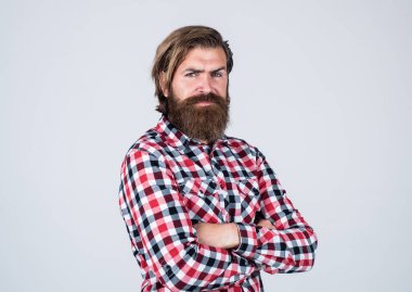 Vahşi sakallı adam kareli gömlek giyiyor, sakalı ve bıyığı gür, berber dükkanı var.