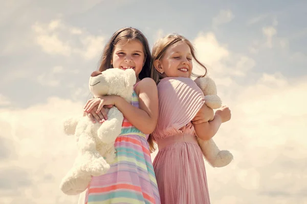 Jsme jedno. rodinný čas na sblížení. nejlepší přátelé drží medvědí hračku. dvě sestry s medvídkem. Šťastné dětství. letní prázdniny. Malá děvčata se obejmou. lásku a podporu. koncepce sesterství a přátelství. — Stock fotografie