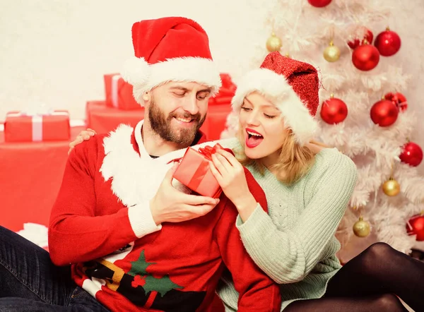 Cadeau aan geliefde. Verliefd stel geniet van kerstvakantie viering met geschenken. Familie maakte kerstcadeaus. Liefdevol paar knuffelen glimlachen tijdens het uitpakken geschenk kerstboom achtergrond — Stockfoto