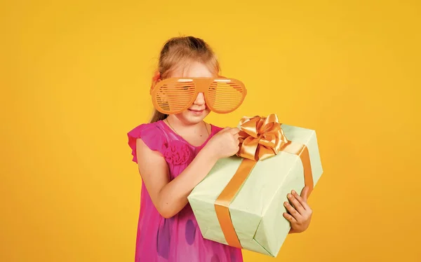 Abrir la caja actual. alegre poco adicto a las compras. estar emocionado y sorprendido de recibir un regalo de cumpleaños. Sonriente niña graciosa. Niño feliz celebrar regalo de compras. Cyber lunes venta. Niños de compras — Foto de Stock