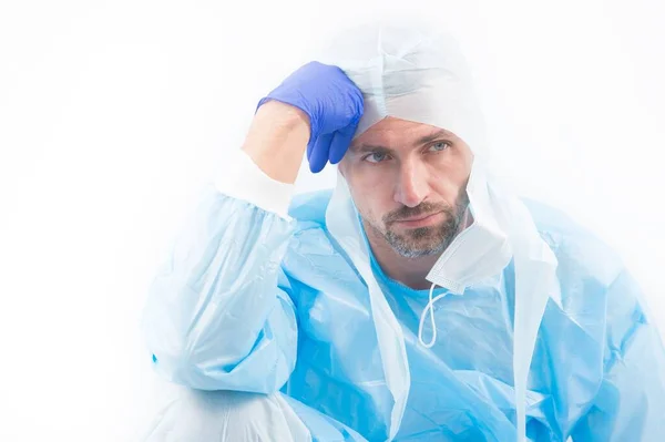 Hombre cansado médico epidemiólogo en traje de protección de seguridad en la cuarentena pandémica coronavirus aislado en blanco pensar en remedio, la creación de la vacuna — Foto de Stock