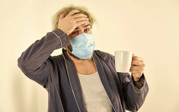 Een man drinkt koffie in een masker. uitbraak van een coronavirus pandemie. Dokter ademhalingsmasker. Ziekenhuis of vervuiling te beschermen gezicht maskeren. medisch masker als corona bescherming — Stockfoto