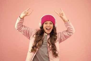 Mutluluk. En sevdiği renk pembe. Küçük çocuk müzik kulaklığı. çocuk uzun kıvırcık saçlı. Kışın saç bakımı. Soğuk hava için sıcak kıyafetler. Tatil zamanı. Mutlu küçük kız pembe bir hayat yaşıyor.