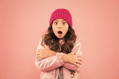 Buz gibi hissediyorum. Soğuk kışa hazır olun. Soğuk iklim havası. Donmuş küçük kız pembe arka plan. çocuk ceketi ve örgü şapka. Kış alışverişi. Hava çok soğuk. Kışın nasıl sıcak giyileceğini