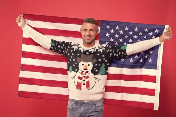Freedom forever. Handsome man celebrate winter holidays red background. Guy wear winter sweater. Merry christmas and happy new year. Best wishes. Winter vacation. Mature man hold american flag
