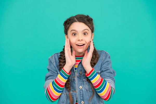 Adorable niño con mirada sorprendida mantener la boca abierta cogida de las manos en la cara piel fondo azul, cuidado de la piel — Foto de Stock