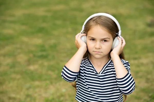 Ciddi şirin çocuk kulaklıkla müzik dinliyor yaz manzarası, ses, fotokopi alanı — Stok fotoğraf