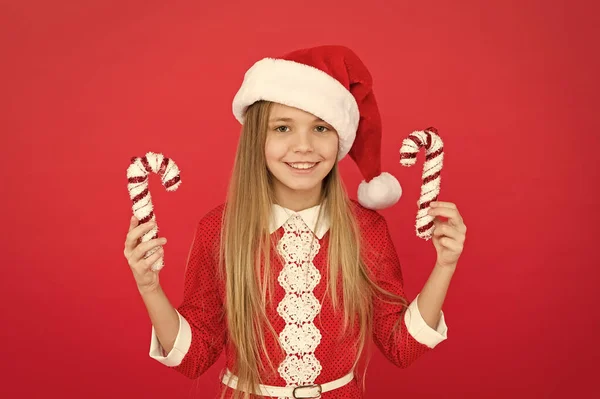 Idées de décoration de Noël. Enfant costume de Père Noël tenir canne à bonbons de Noël. Créez des décorations uniques. Jolie enfance. Canne à bonbons rayée traditionnelle pour les vacances d'hiver. Décor de Noël — Photo