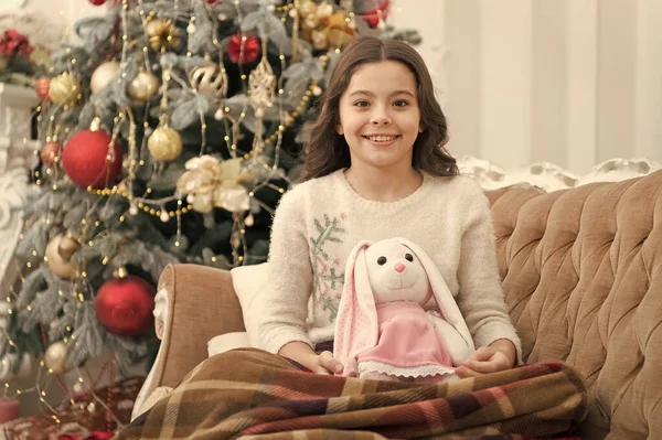 축하하자. 집에서 아늑 함을 느끼는 것. 새해 복 많이 받아. 행복과 기쁨. xmas presents 에 준비되어 있습니다. 작은 소녀는 토끼를 사랑 합니다. 최고의 크리스마스 장난감이야. 크리스마스 트리에서 놀고 있는 쾌활 한 아이 — 스톡 사진