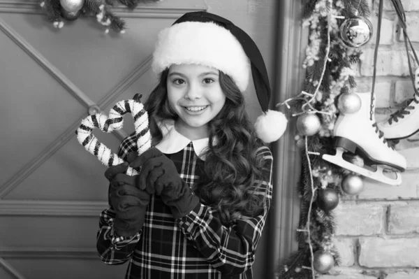 クリスマスの装飾。ペパーミントキャンディ。アイデアを飾る。子供はクリスマスの杖を持っている。伝統的な冬の休暇を縞模様のキャンディー杖。帽子と手袋でエレガントな幸せな子供。サンタクロースを待っています — ストック写真
