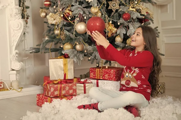 クリスマスの魔法を信じなさい。クリスマスツリーの下の子供。小さな子供はクリスマスツリーを飾る。幸せな子供はクリスマスと新年を祝います。小さい子供はお祝いの季節を楽しむ。メリークリスマス。明けましておめでとうございます — ストック写真