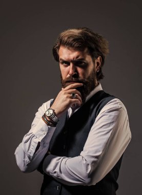 Gri arka planda yakışıklı bir adam. Ciddi sakallı iş adamı. Modern görünümlü şık, olgun bir adam. Erkek ofisindeki gardırop. Takım elbiseli şık bir adam. resmi model