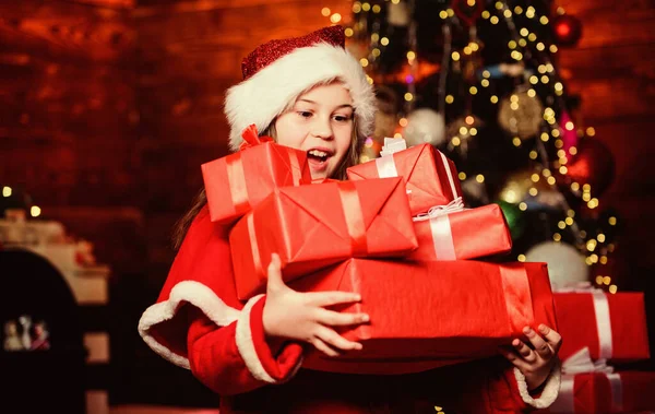 Todos receberão um presente. A menina do Pai Natal. Compras de Natal. Menina de chapéu vermelho. Dia das compras. Tempo de Natal. Venda de compras. Criança duende. Árvore de Natal. Compras de férias. Feliz Ano Novo — Fotografia de Stock