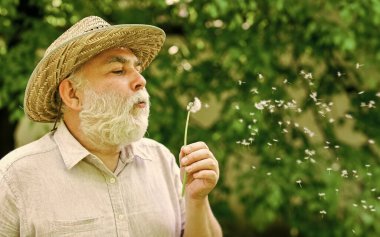 Huzur dolu. Huzur ve sükunet. Mutlu ve kaygısız emeklilik. Yalnız dede parkta karahindiba tohumu saçıyor. Akıl sağlığı. İçim rahat olsun. Ruhun ahengi. Hasır şapkalı yaşlı adam.