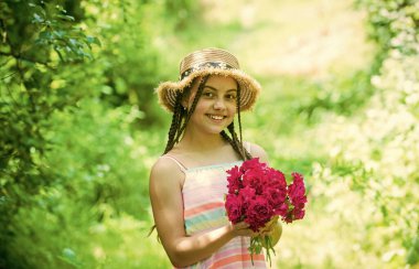 Yaz gülü buketi olan küçük bir kız. Yaz tatili ve tatil. Kadın güzelliği ve moda. çocukluk mutluluğu. Mutlu çocuk çiçek topluyor. Bahar parkında ya da bahçede çocuk yürüyüşü
