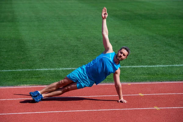 Musclé homme debout dans la planche latérale étirement sur l'entraînement sportif, yoga — Photo