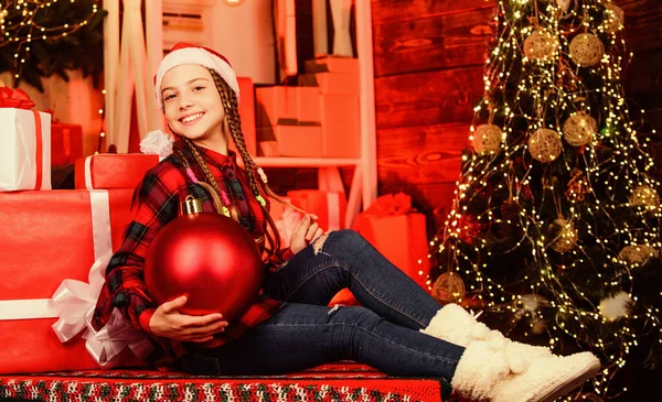 Christmas concept. Child fancy santa enjoy celebration new year. Decor shop. Favorite color. Red style. Spread love. Winter holiday. Small cute girl with big ball christmas tree. Christmas spirit