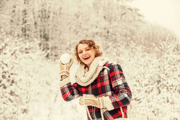 Una niña con un suéter y gafas en invierno en un bosque cubierto de nieve.