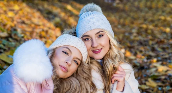 Hezké ženy s dlouhými kudrnatými blond vlasy nosí podzimní klobouk v lese s spadlým listím, teplé oblečení — Stock fotografie
