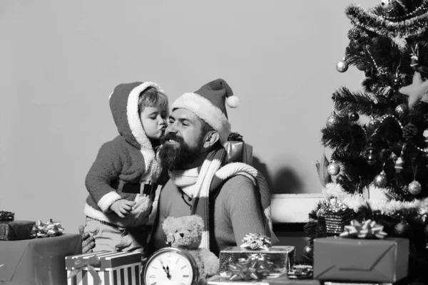 Noel ailesi hediyelerini pembe arka planda açar. — Stok fotoğraf